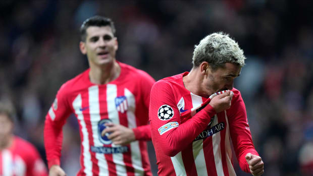 Antoine Griezmann pictured (right) kissing the badge on his Atletico Madrid shirt after scoring against Celtic in November 2023